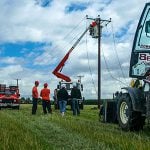 Tractor in a field with overhead construction line equipment